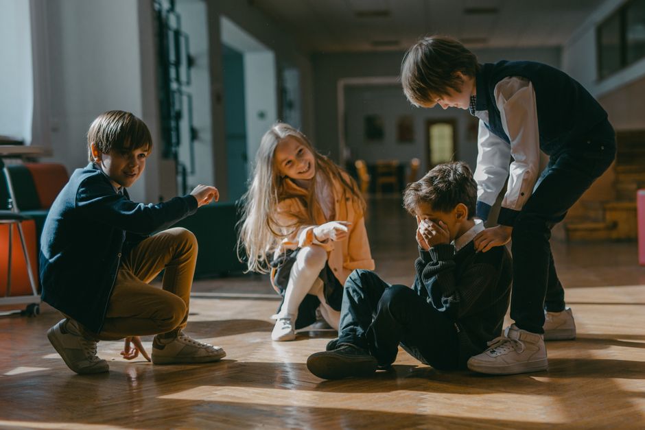 Crianças brincando e se divertindo em um ambiente interno iluminado, criando uma atmosfera de alegria e interação entre amigos.