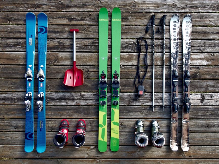Imagem de equipamento de esqui organizado sobre uma superfície de madeira, perfeito para ilustrar preparativos e aventura na neve.