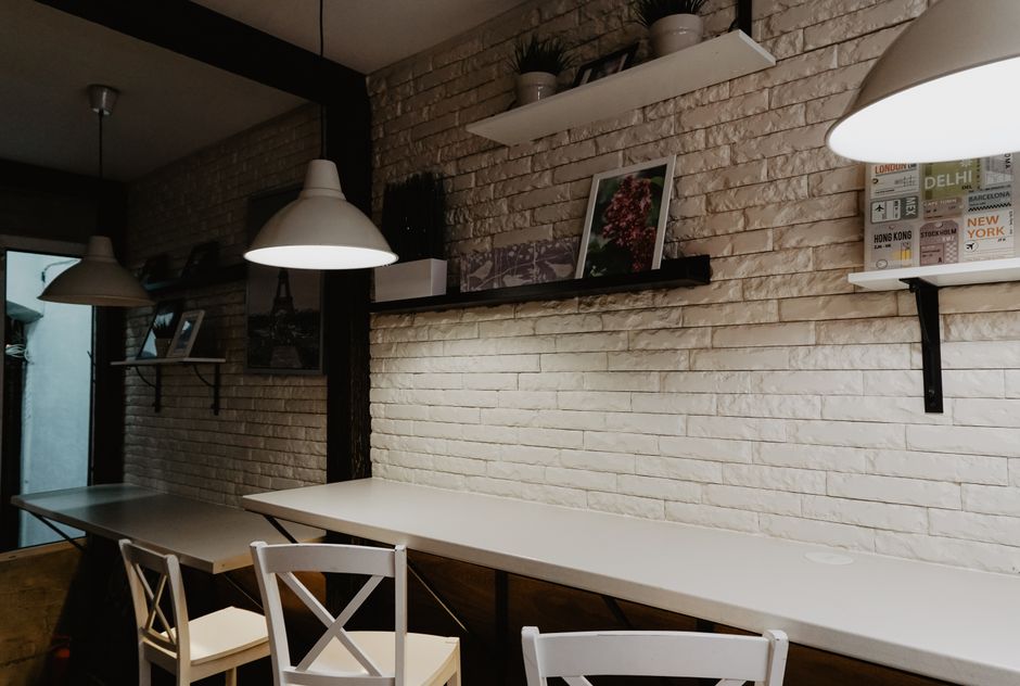 Ambiente de coworking com iluminação moderna e decoração clean, ideal para estudos ou reuniões de trabalho.
