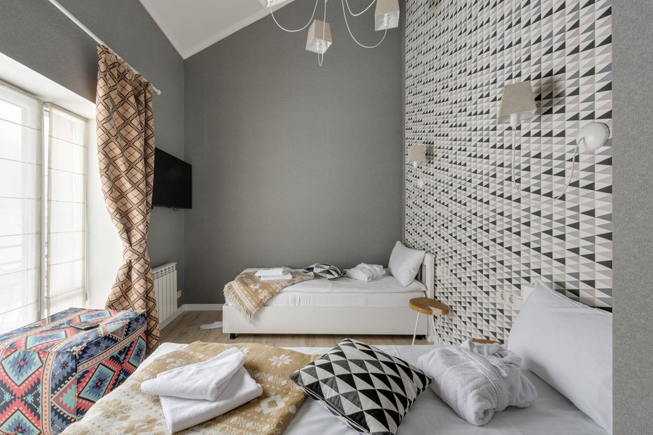 Quarto moderno com decoração geométrica, ideal para fotos de hospedagem ou design de interiores de hotéis boutique.