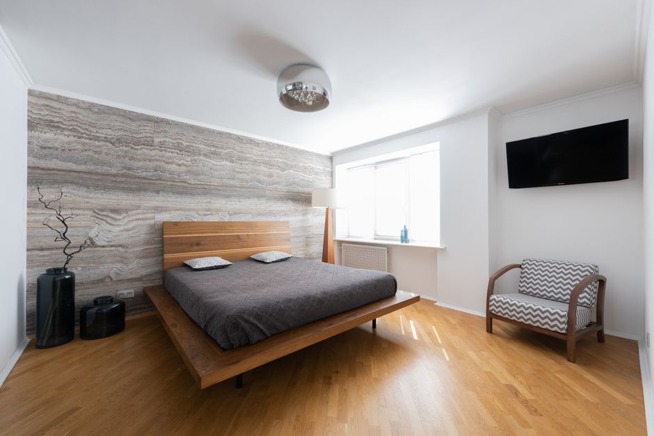 Quarto moderno com decoração minimalista e iluminação natural, ideal para ambientes de hospedagem ou residenciais elegantes.