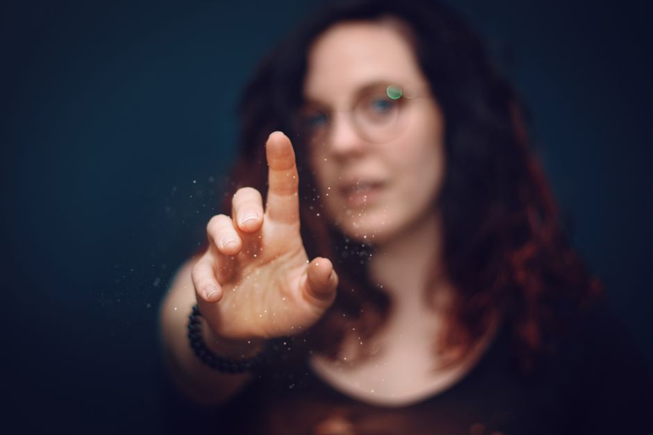 Mulher com óculos fazendo um gesto focalizado, transmitindo uma sensação de descoberta ou inovação, ideal para um blog sobre criatividade ou inovação.