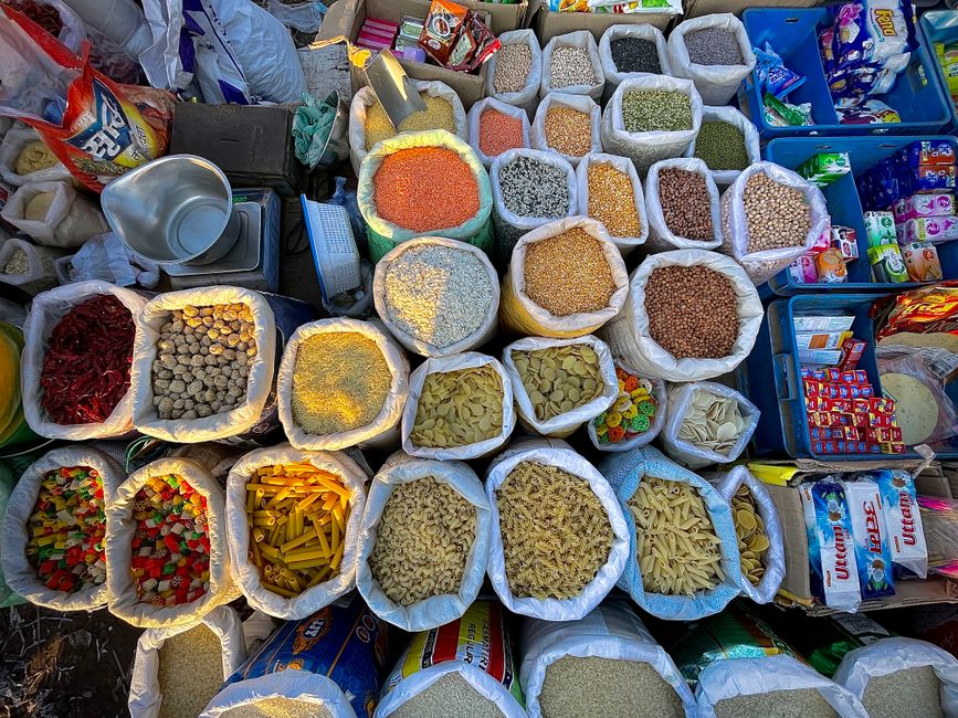 Vários sacos de diferentes tipos de grãos e massas em forma de uma feira ou ponto de venda de alimentos a granel.