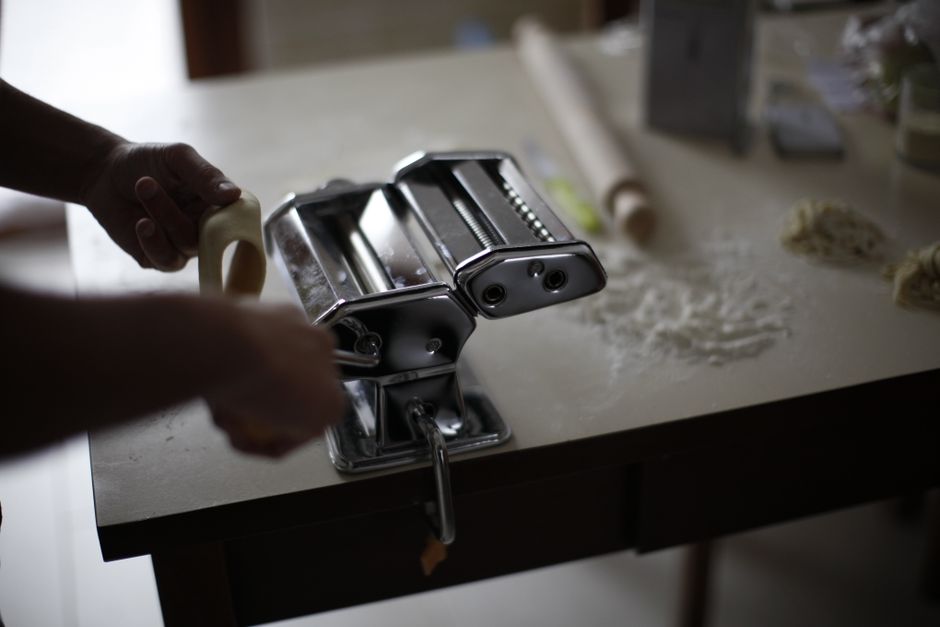 Cena de uma bancada de cozinha com uma massa de pão sendo preparada, destacando o processo culinário caseiro e artesanal.