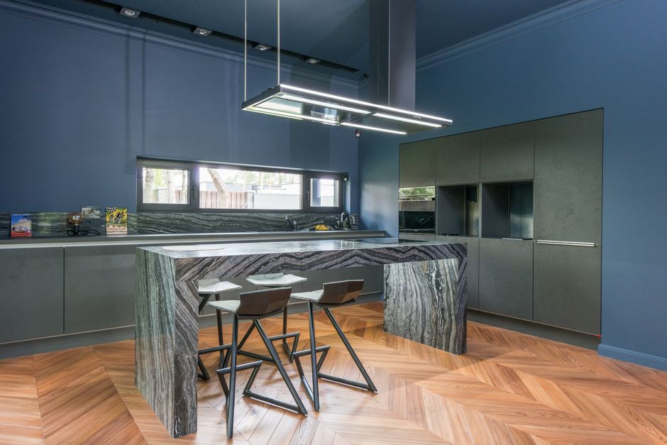 Imagem de uma cozinha moderna com design minimalista em tons de cinza e detalhes em mármore, ideal para ilustrar decoração de interiores sofisticada.