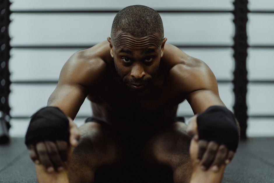 Atleta de artes marciais em posição de luta, demonstrando força e foco durante treinamento ou competição.