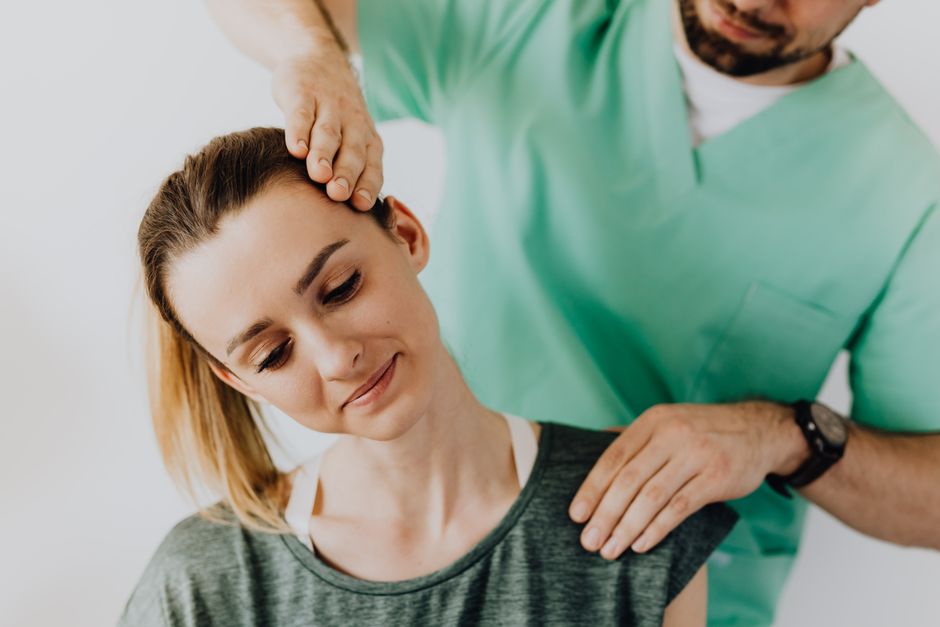 Profissional de saúde realizando uma avaliação ou terapia de fisioterapia em uma jovem paciente em ambiente clínico.