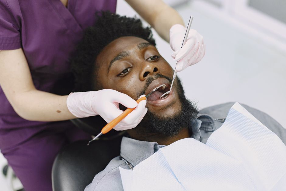 Paciente realizando exame odontológico com profissional na clínica, destacando cuidados bucais.