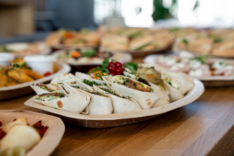 Prato de wraps gourmet com verduras frescas e frutas, ideal para um brunch ou evento social.