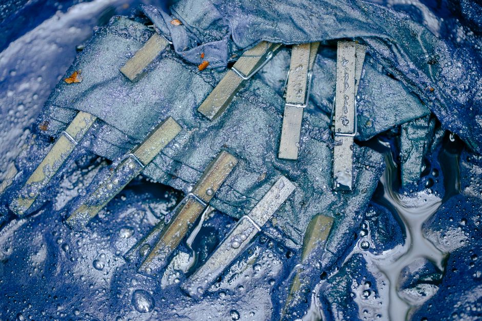 Imagem de roupas molhadas com grampos, sugerindo lavagem e cuidados com as roupas.