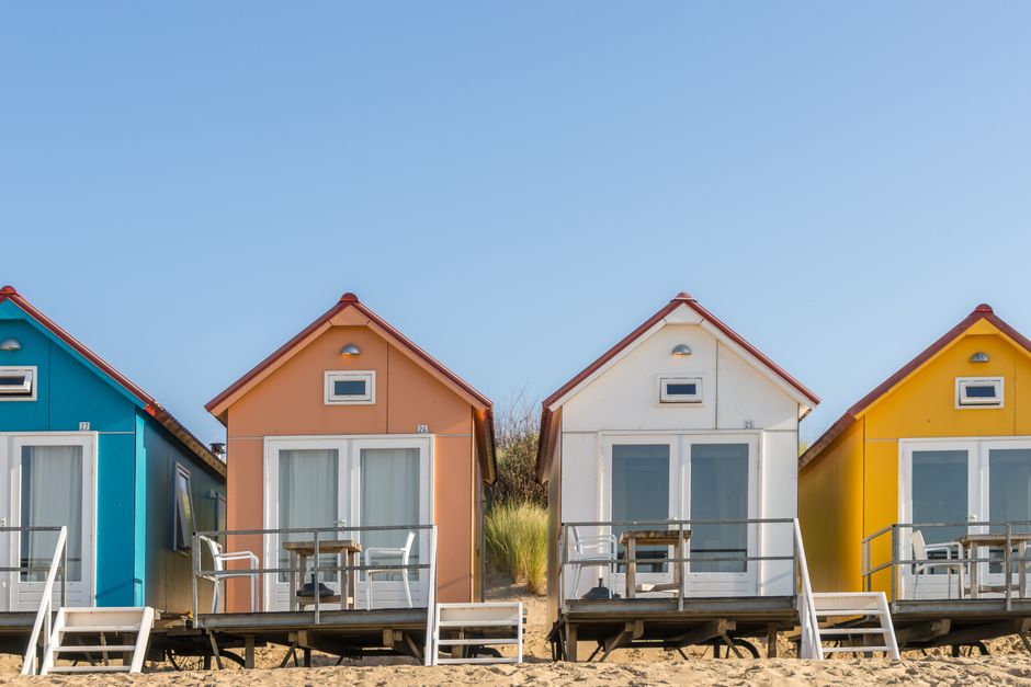 Casas coloridas em uma praia, refletindo um cenário de lazer e turismo.