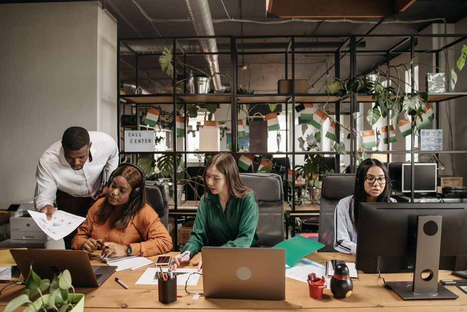 Equipe de profissionais colaborando em ambiente de escritório, focada em trabalho em equipe e produtividade.