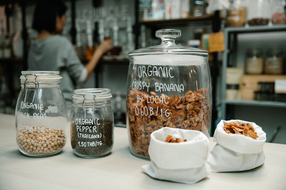 Imagem de um ambiente de loja ou mercado com potes de produtos orgânicos, indicando foco em alimentação saudável e sustentabilidade.