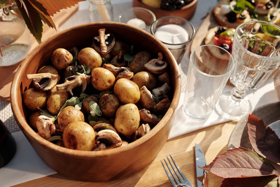 Imagem de uma mesa ao ar livre com ingredientes naturais e elementos de preparação de comida, sugerindo um momento de refeição ou convivência gastronômica em um ambiente rústico.