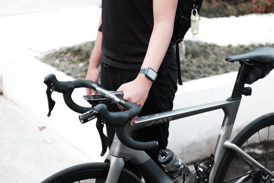 Pessoa preparando sua bike elétrica para uma pedalada em ambiente urbano, destacando o transporte sustentável e a mobilidade ativa.
