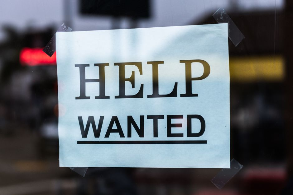 Aviso de busca de ajuda ou recrutamento exposto em uma vitrine de loja ou estabelecimento comercial.