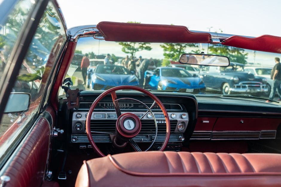Interior de carro clássico em um encontro de veículos antigos, destacando o design vintage e o ambiente de exposição automotiva.