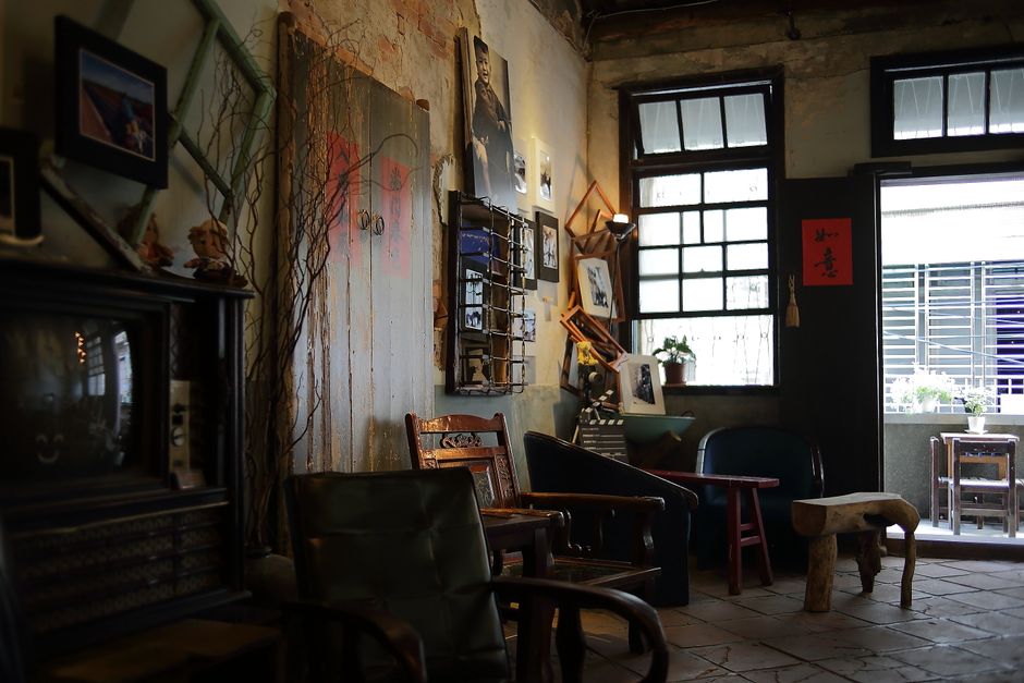 Espaço aconchegante de uma cafeteria ou sala de convivência com decoração vintage e iluminação natural, ideal para encontros ou momentos de relaxamento.