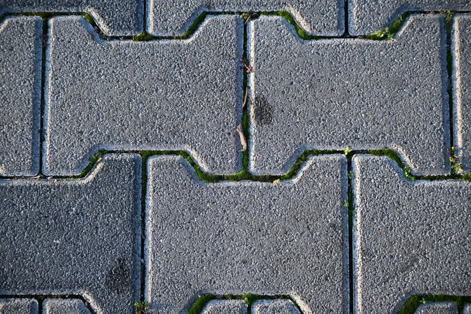Imagem de um piso de pedras intertravadas com uma rachadura no centro, evidenciando uma separação na superfície