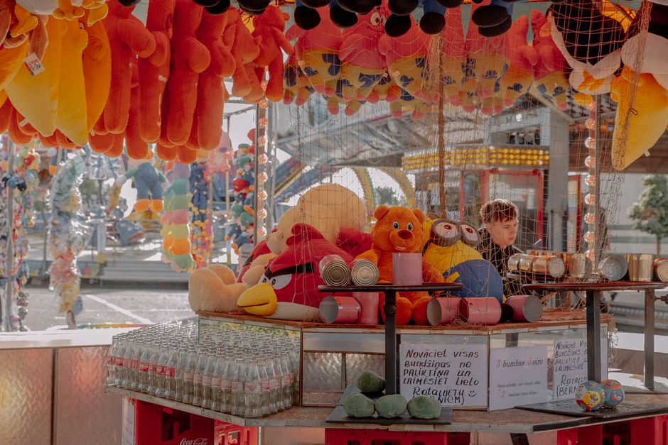 Imagem de uma barraca de feira com brinquedos de pelúcia coloridos, destacando a diversão e comércio em um ambiente ao ar livre.