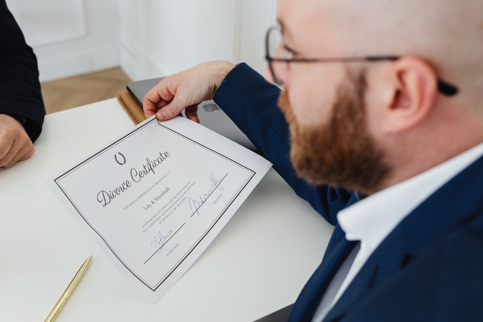 Homem recebendo um certificado de divórcio, simbolizando processos legais e mudanças pessoais.