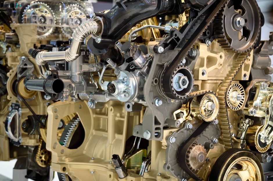 Imagem de um motor de automóvel em detalhes, destacando componentes mecânicos e engrenagens.