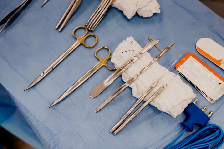 Equipamentos médicos de cirurgia dispostos sobre uma mesa, prontos para serem utilizados durante um procedimento cirúrgico.
