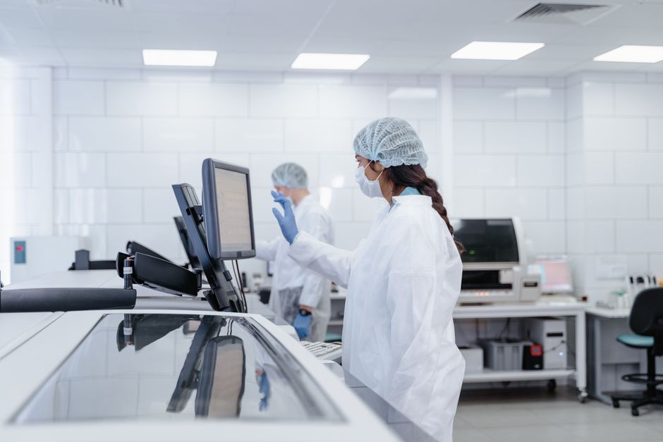 Profissionais de saúde atuando em um laboratório de alta tecnologia, com foco na precisão e segurança dos procedimentos laboratoriais.