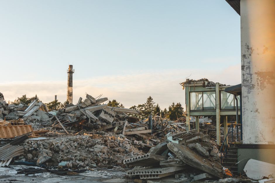 Cenário de destruição e destruição de construções após um desastre ou incidente catastrófico, refletindo perda e evacuação de áreas urbanas.