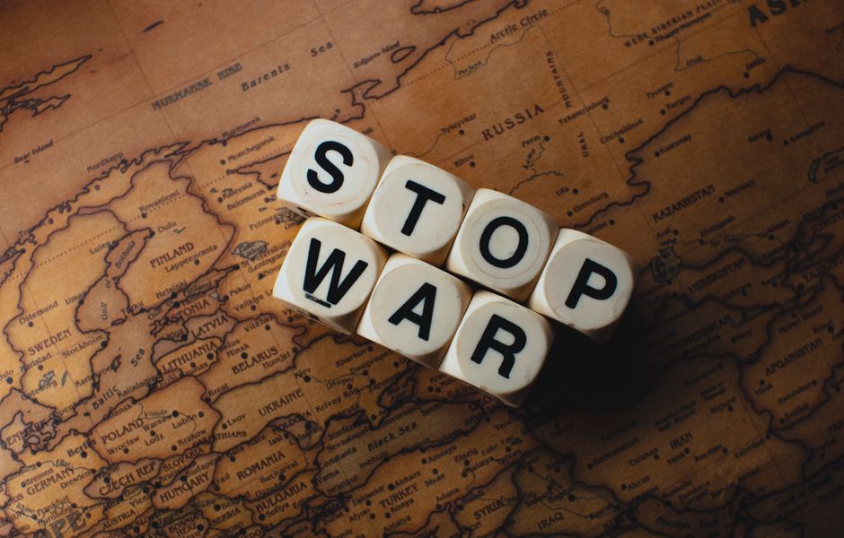 imagem com blocos de letras formando a frase 'STOP WAR' sobre um mapa do mundo, simbolizando protesto contra conflitos globais