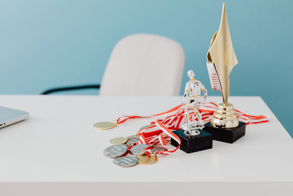 Imagem de prêmios e medalhas de esportes, simbolizando conquista e reconhecimento em atividades atléticas.