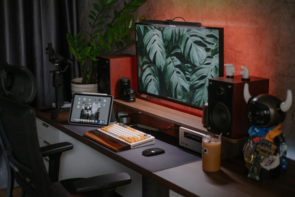 Configuração de um espaço de trabalho criativo com tecnologia, iluminação suave e elementos decorativos que refletem produtividade e estilo pessoal.