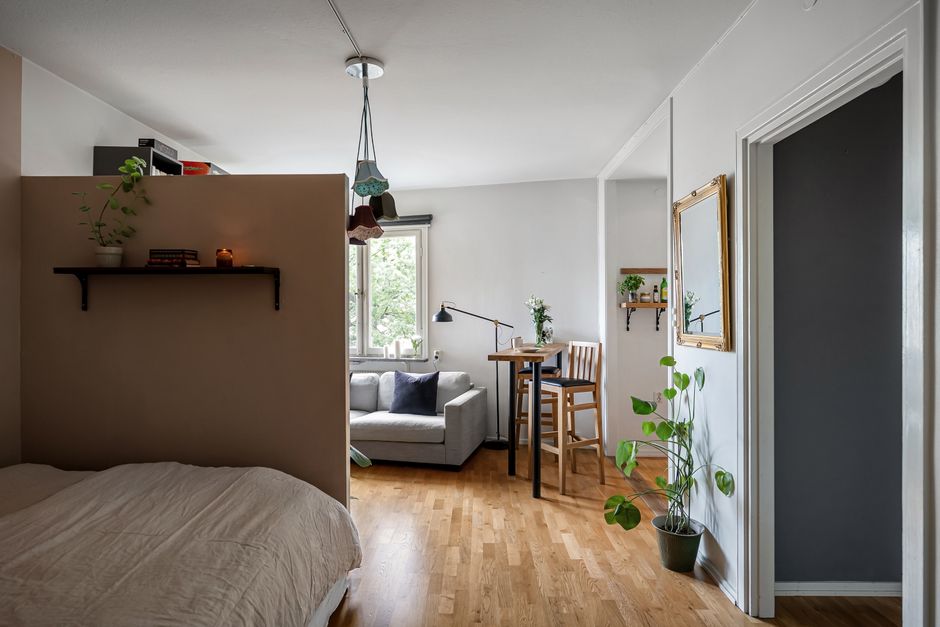 Imagem de um espaço de convivência em uma casa moderna com uma área de trabalho, sofá e elementos decorativos que trazem aconchego e funcionalidade.