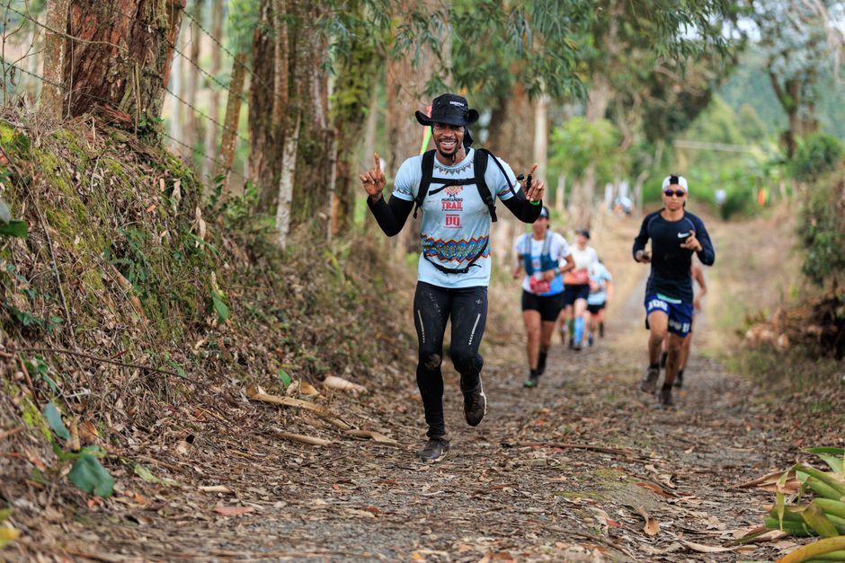 Grupo de corredores participando de uma trilha ao ar livre em meio à natureza, durante uma corrida de aventura ou trail running.
