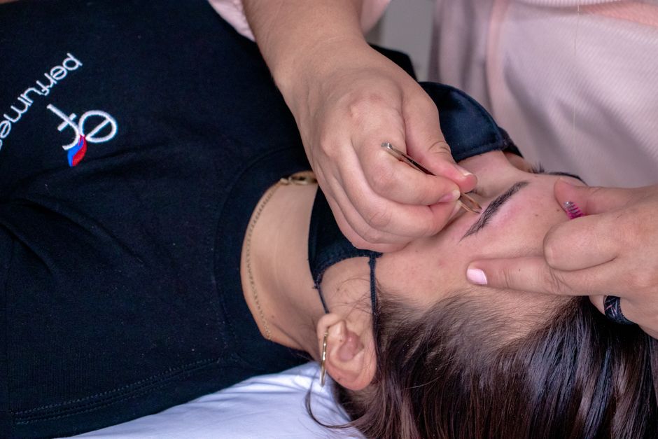 Uma pessoa recebendo um procedimento de estética facial por um profissional em um ambiente de clínica de beleza ou estética.