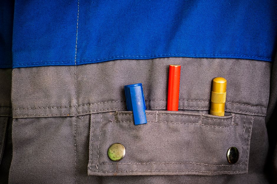 Imagem de uma pessoa de uniforme com três marcadores coloridos na parte de trás da calça, simbolizando organização e planejamento.