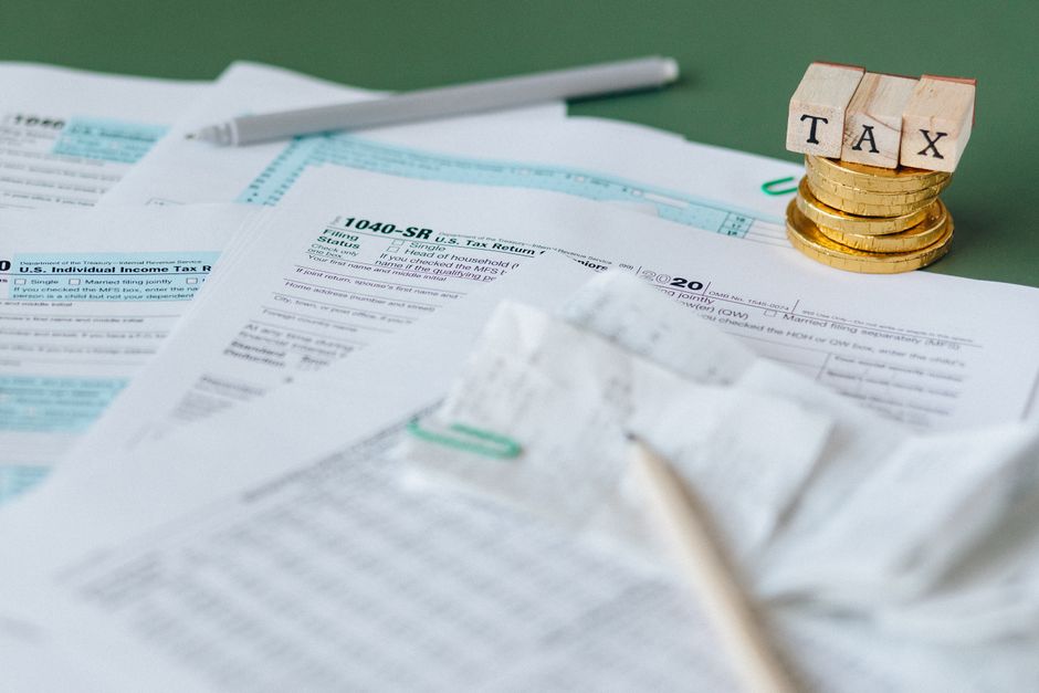 Documentos fiscais, moedas e blocos de madeira com a palavra TAX
