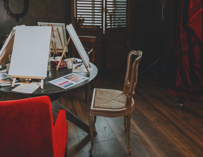 Espaço criativo de trabalho com telas de pintura e materiais artísticos, ideal para projetos de arte e design