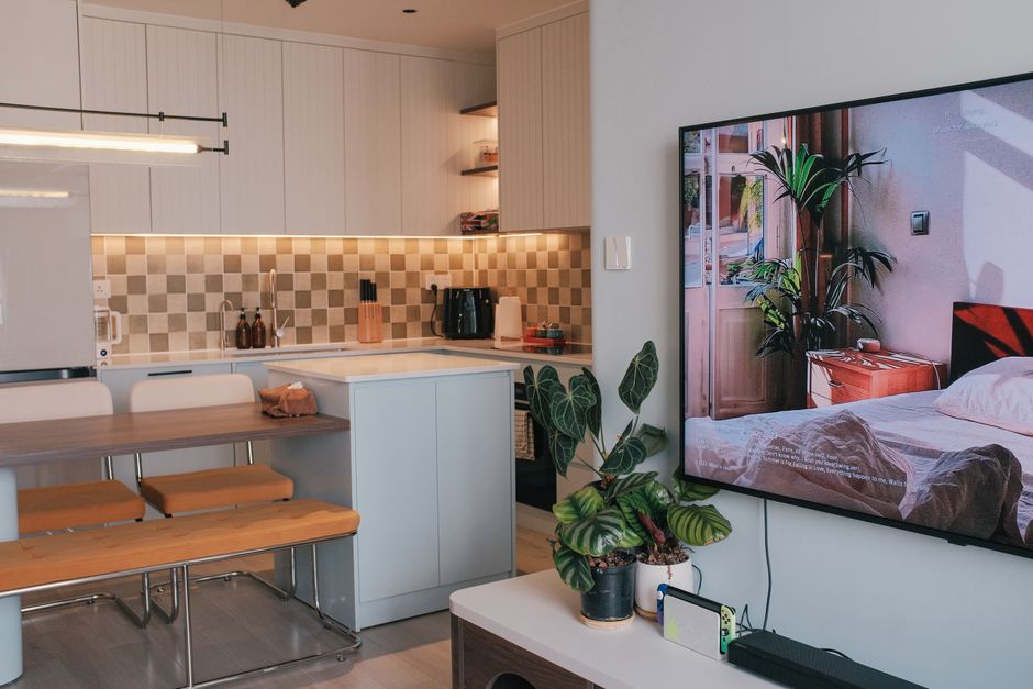 Imagem de uma cozinha moderna integrada a uma sala de estar, destacando ambientes de convivência em um apartamento elegante.