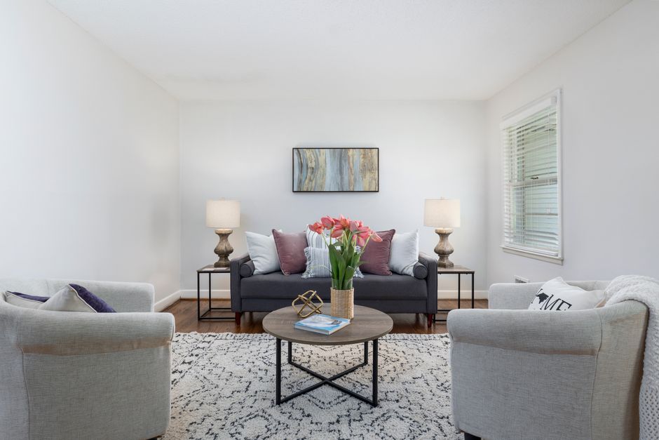 Salão de estar clean e acolhedor com móveis confortáveis, iluminação suave e decoração minimalista, ideal para um artigo sobre decoração de interiores ou ambientes residenciais elegantes.