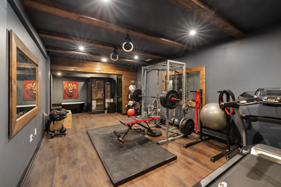 Espaço de treino funcional com equipamentos de musculação, esteira e elementos de ginástica em um ambiente com iluminação e decoração moderna.