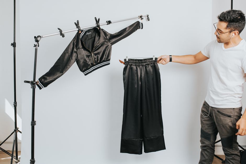 Homem testando roupas de moda em um cenário de ensaio fotográfico para um blog de tendências de vestuário.