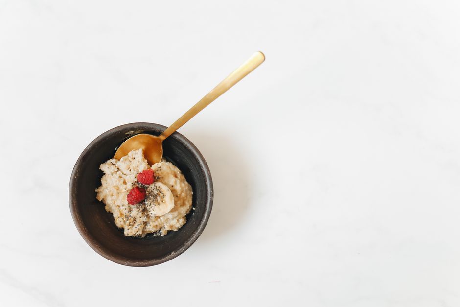 Imagem de um bowl com aveia, banana e morangos, ideal para ilustrar alimentos saudáveis e coffee break em oficinas de saúde ou bem-estar.