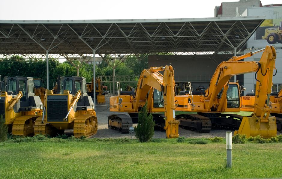 Exposição de escavadeiras e máquinas pesadas em uma área de vendas ou aluguel de equipamentos de construção.