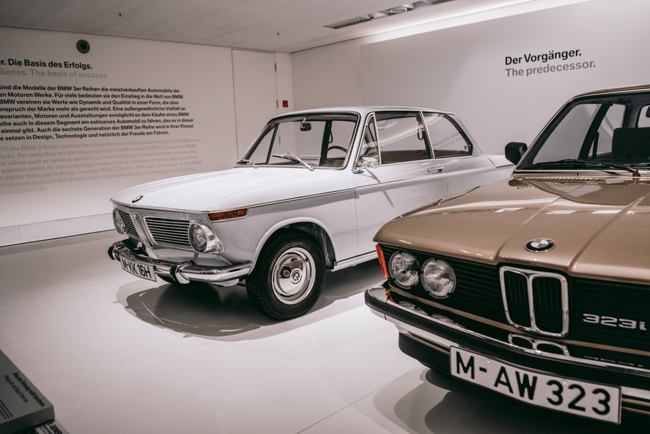 Duas clássicas BMW em exibição em um museu, destacando a história e a evolução do design automotivo.