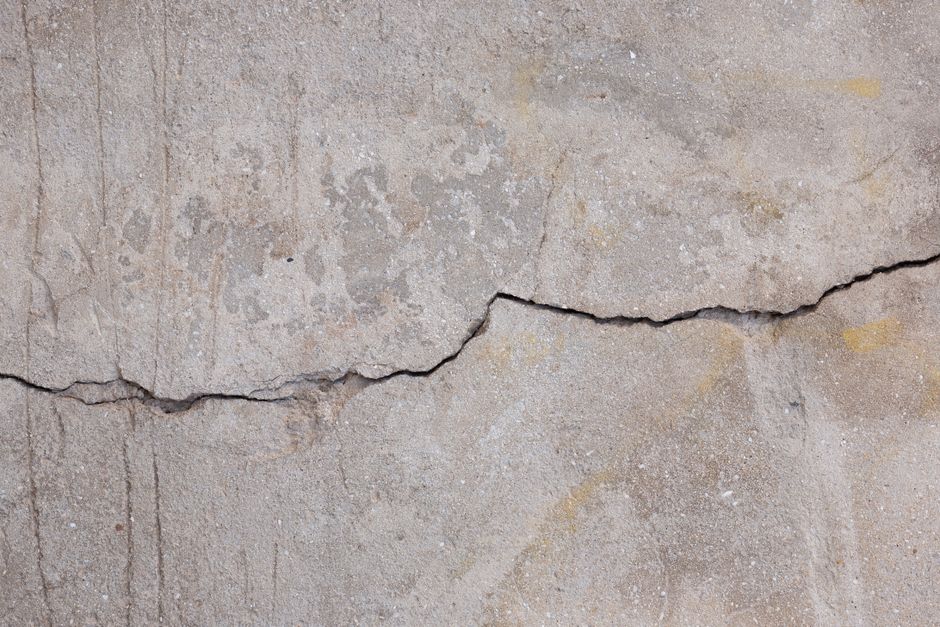 Imagem de uma parede de concreto com rachadura, simbolizando vulnerabilidade ou necessidade de reparos em um contexto de manutenção ou construção.