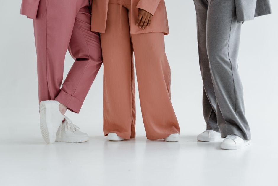 Três pessoas de terno em cores diferentes, destacando a união e diversidade no ambiente de trabalho formal.