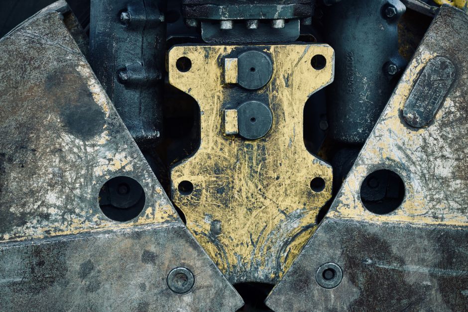 Imagem de uma máquina industrial robusta, destacando sua estrutura metálica e componentes de uso pesado.