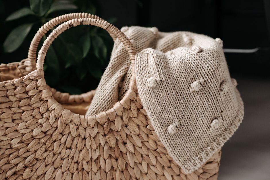 Imagem de uma cesta de vime com roupa de algodão bege, destacando o tema de moda, estilo de vida ou sustentabilidade.