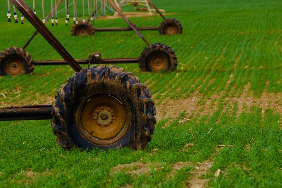 Imagem de uma máquina de irrigação automatizada em um campo de plantio, ilustrando temas de agricultura inteligente e gestão agrícola sustentável.